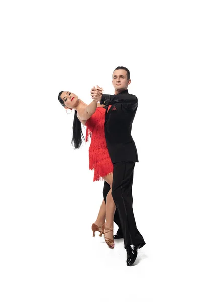 Paar eleganter Tänzer, die in die Kamera schauen, während sie Tango auf weißem Hintergrund tanzen — Stockfoto