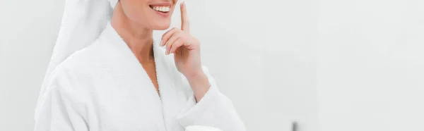 Plano panorámico de la mujer aplicando crema cosmética en la cara limpia - foto de stock