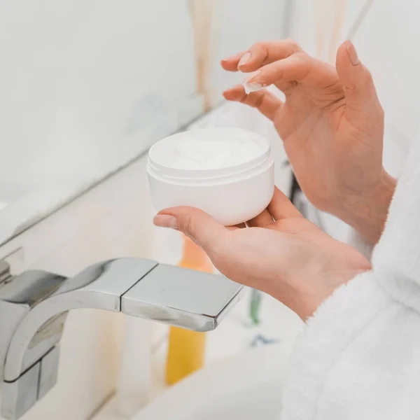 Cropped view of woman holding container with face cream — Stock Photo