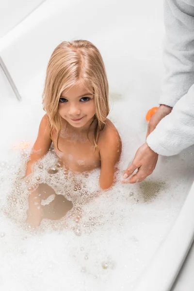 Vue aérienne de mignon enfant prenant un bain près de la mère — Photo de stock