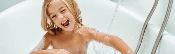 Panoramic shot of happy naked kid taking bath — Stock Photo