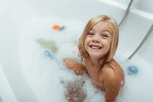 Felice bambino nudo che fa il bagno con schiuma da bagno a casa — Foto stock