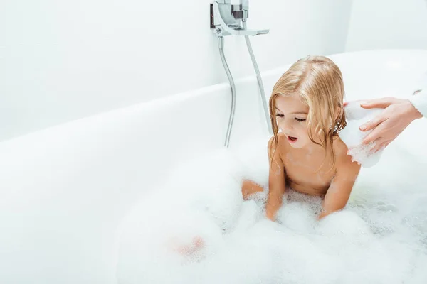 Adorable enfant prenant un bain près de la mère à la maison — Photo de stock