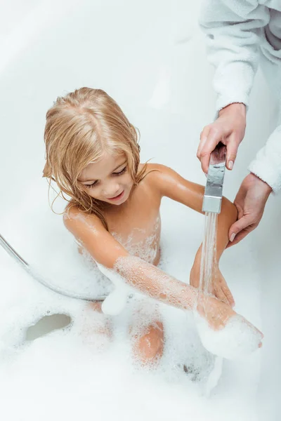 Vista aérea de la madre lavado niño lindo y desnudo en el baño - foto de stock