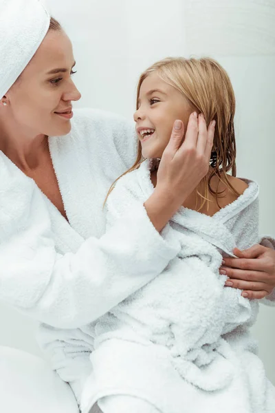 Mãe feliz tocando rosto de filha bonito no banheiro — Fotografia de Stock