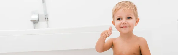 Tiro panorámico de niño feliz gesto en el baño - foto de stock