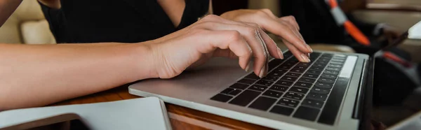 Panoramic shot of businesswoman using laptop in private jet — Stock Photo