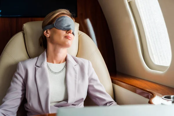 Donna d'affari con maschera addormentata seduta in aereo privato — Foto stock