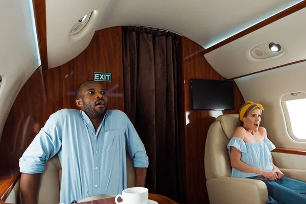 Scared african american man and woman with fear of flight in private plane — Stock Photo