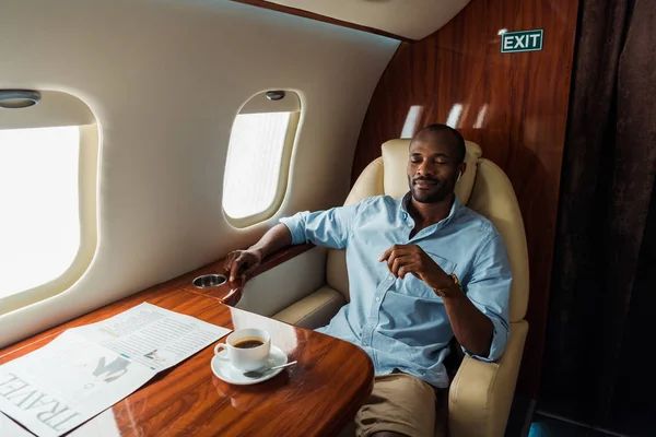 Bel homme afro-américain écoutant de la musique en avion privé — Photo de stock