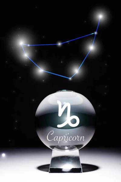 Bola de cristal com signo do zodíaco Capricórnio isolado em preto com constelação — Fotografia de Stock