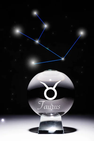 Boule de cristal avec signe du zodiaque Taurus isolé sur noir avec constellation — Photo de stock