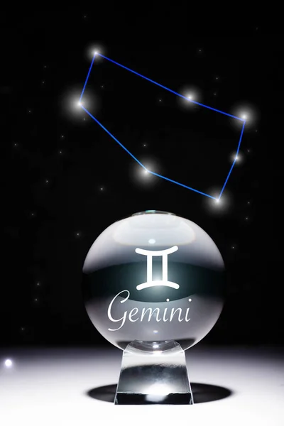 Crystal ball with Gemini zodiac sign isolated on black with constellation — Stock Photo