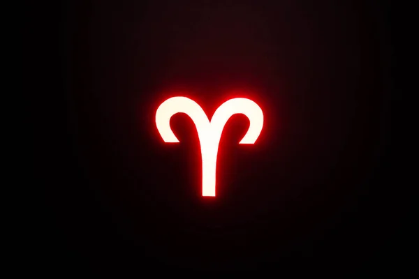 Rojo iluminado signo del zodíaco de Aries sobre fondo negro - foto de stock