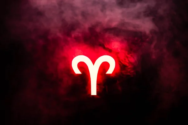Red illuminated Aries zodiac sign with smoke on background — Stock Photo