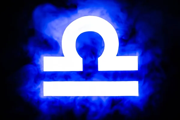 Signo del zodíaco Libra iluminado azul con humo en el fondo - foto de stock