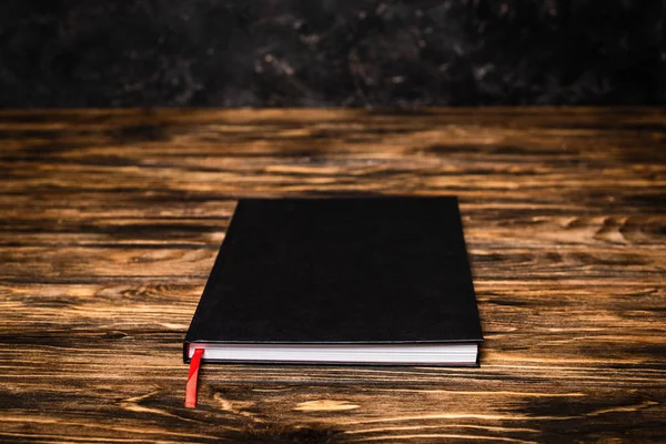 Black book on wooden table — Stock Photo