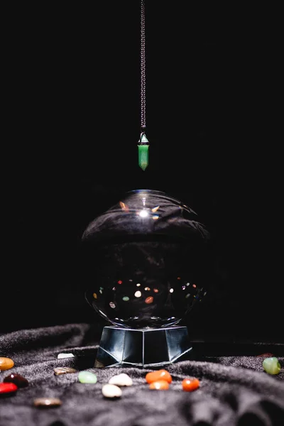 Fortune telling stone above crystal ball on black velvet cloth isolated on black — Stock Photo