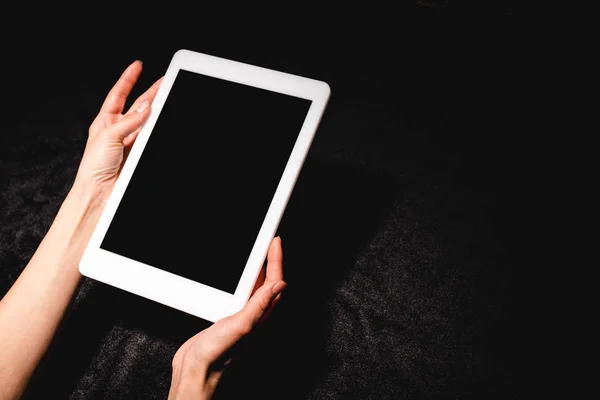 Обрізаний вид жінки, що тримає цифровий планшет з порожнім екраном на чорній оксамитовій тканині — стокове фото