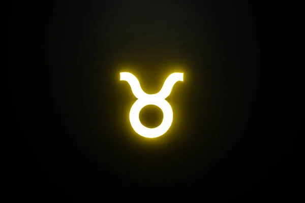 Желтый подсвеченный знак зодиака Телец изолирован на черном — стоковое фото