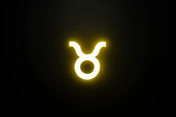 Yellow illuminated Taurus zodiac sign isolated on black — Stock Photo