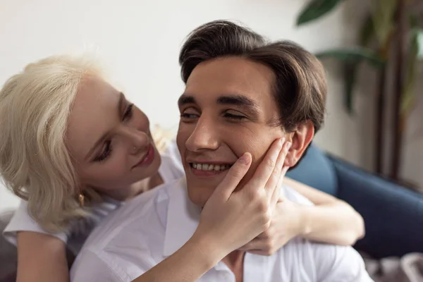 Sourire fille blonde toucher le visage du petit ami à la maison — Photo de stock