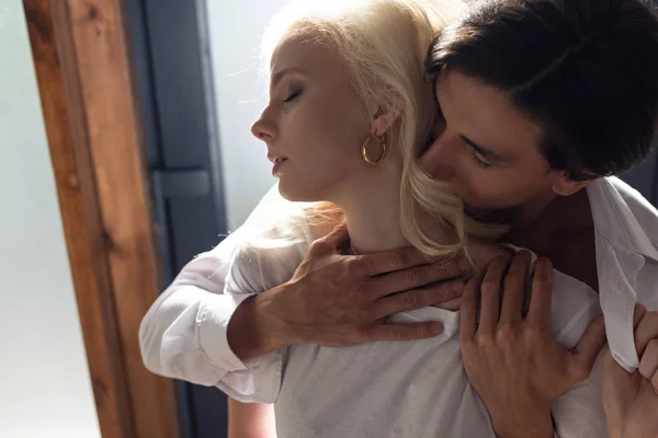 Man hugging attractive blonde woman in sunlight — Stock Photo