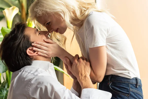 Vue latérale du couple souriant se regardant à la maison — Photo de stock