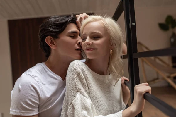 Man whispering to smiling blonde girl at home — Stock Photo