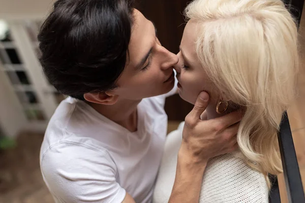 Overhead view of man kissing blonde girlfriend at home — Stock Photo