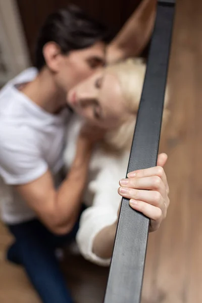 Foyer sélectif de l'homme embrasser petite amie par balustrade balcon — Photo de stock