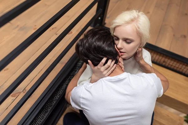 Young couple hugging and kissing on stairs at home — Stock Photo