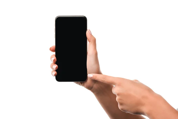 Abgeschnittene Ansicht einer Frau, die mit dem Finger auf ein Smartphone zeigt, mit leerem Bildschirm isoliert auf Weiß — Stockfoto