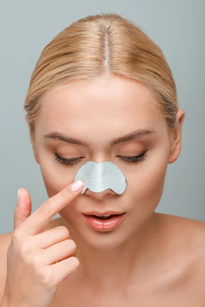 Nackte Frau berührt Nasenstreifen im Gesicht isoliert auf grau — Stockfoto