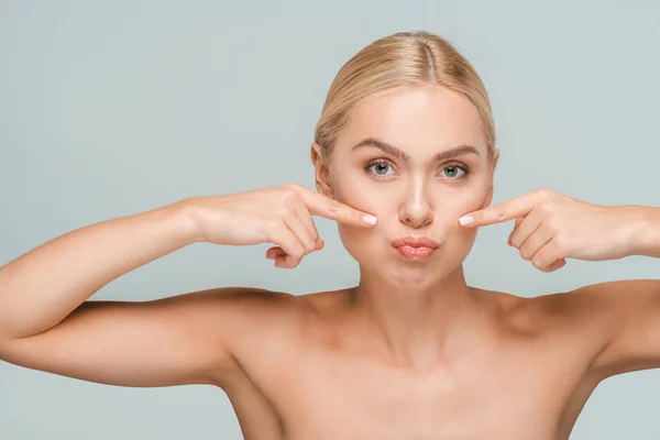 Naked woman pointing with fingers at clean face isolated on grey — Stock Photo