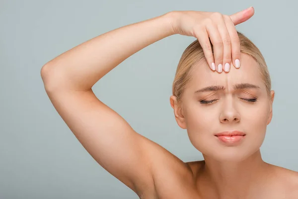 Junge aufgebrachte Frau berührt Stirn isoliert auf grau — Stockfoto