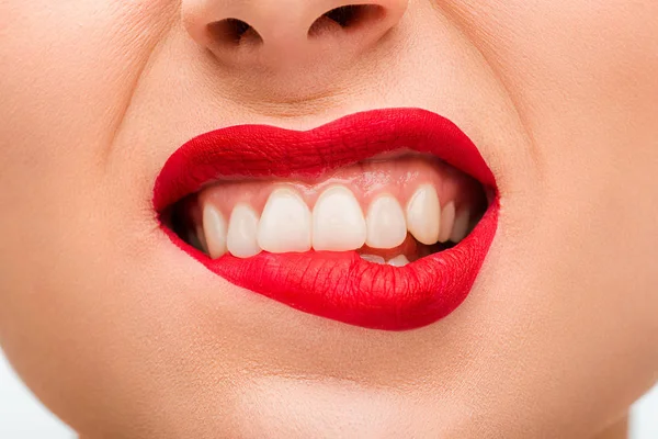 Vista ritagliata di emotivo giovane donna con rossetto rosso mordere le labbra — Foto stock