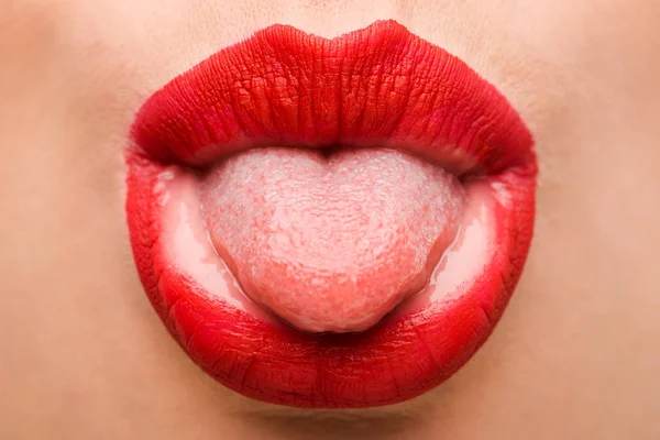 Vista recortada de chica con lápiz labial rojo que sobresale lengua aislada en blanco - foto de stock