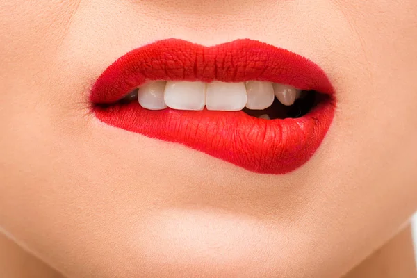 Recortado vista de sexy mujer joven con lápiz labial rojo morder los labios - foto de stock