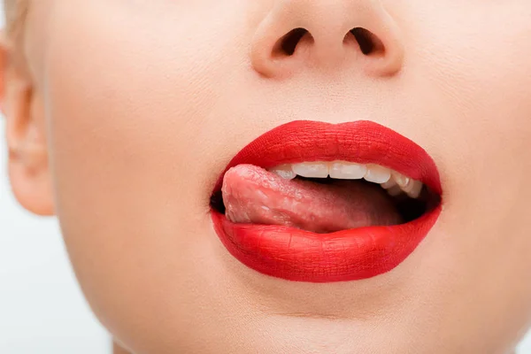 Vue recadrée de la femme avec rouge à lèvres léchant lèvres isolées sur blanc — Photo de stock