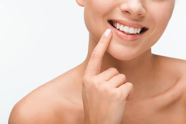 Cropped view of happy woman pointing with finger at face isolated on white — Stock Photo