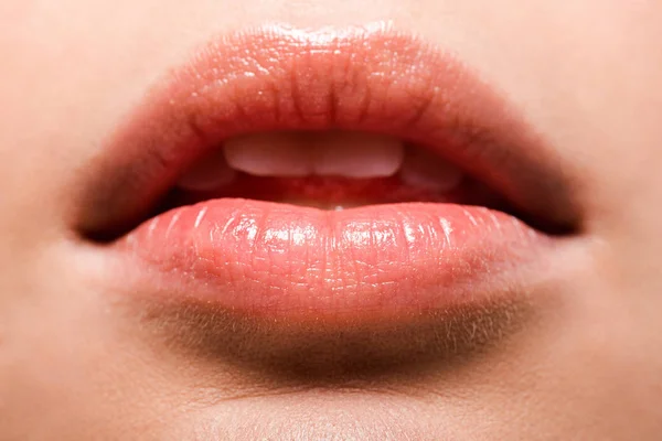 Primer plano de la mujer con brillo labial brillante en los labios - foto de stock