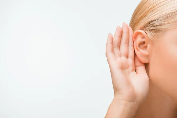 Vue recadrée de la femme blonde toucher l'oreille tout en écoutant isolé sur blanc — Photo de stock