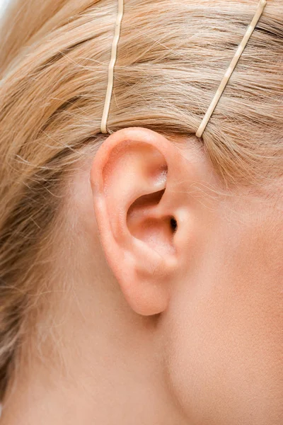 Cropped view of young woman with golden hairpins — Stock Photo