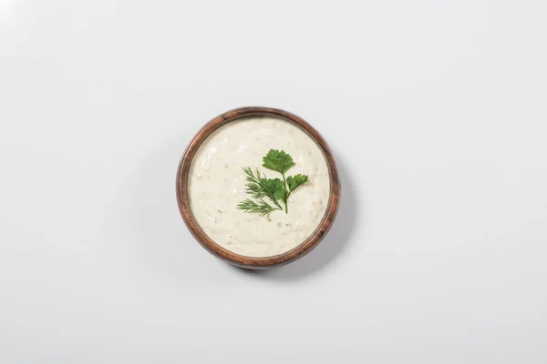 Top view of homemade tzatziki sauce in wooden bowl on white background — Stock Photo