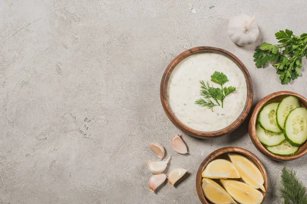 Vista dall'alto della salsa tzatziki con ingredienti sulla superficie di pietra — Foto stock