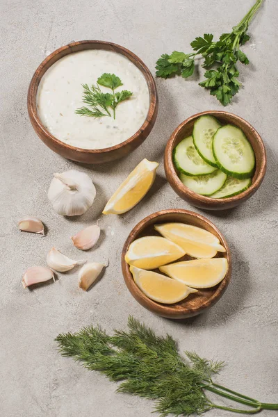 Traditional greek tzatziki sauce from yogurt, cucumber with lemon and garlic on stone background — Stock Photo