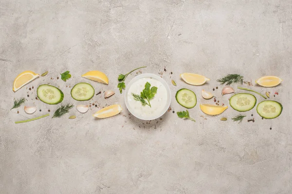 Top view of tzatziki sauce with ingredients and spices on stone background — Stock Photo