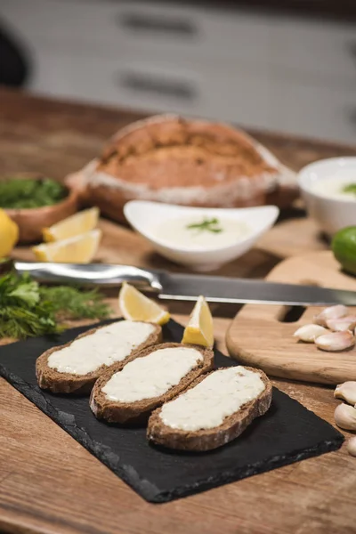 Brot mit Tzatziki-Sauce mit frischen Zutaten auf Holztisch — Stockfoto