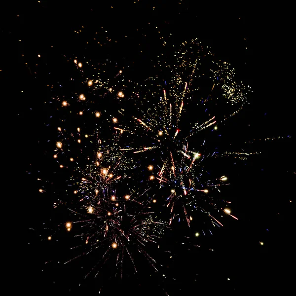 Fuegos artificiales tradicionales dorados en el cielo nocturno, aislados en negro - foto de stock